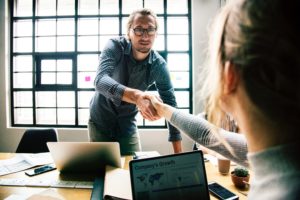Woman shaking hands with man at sales job interview